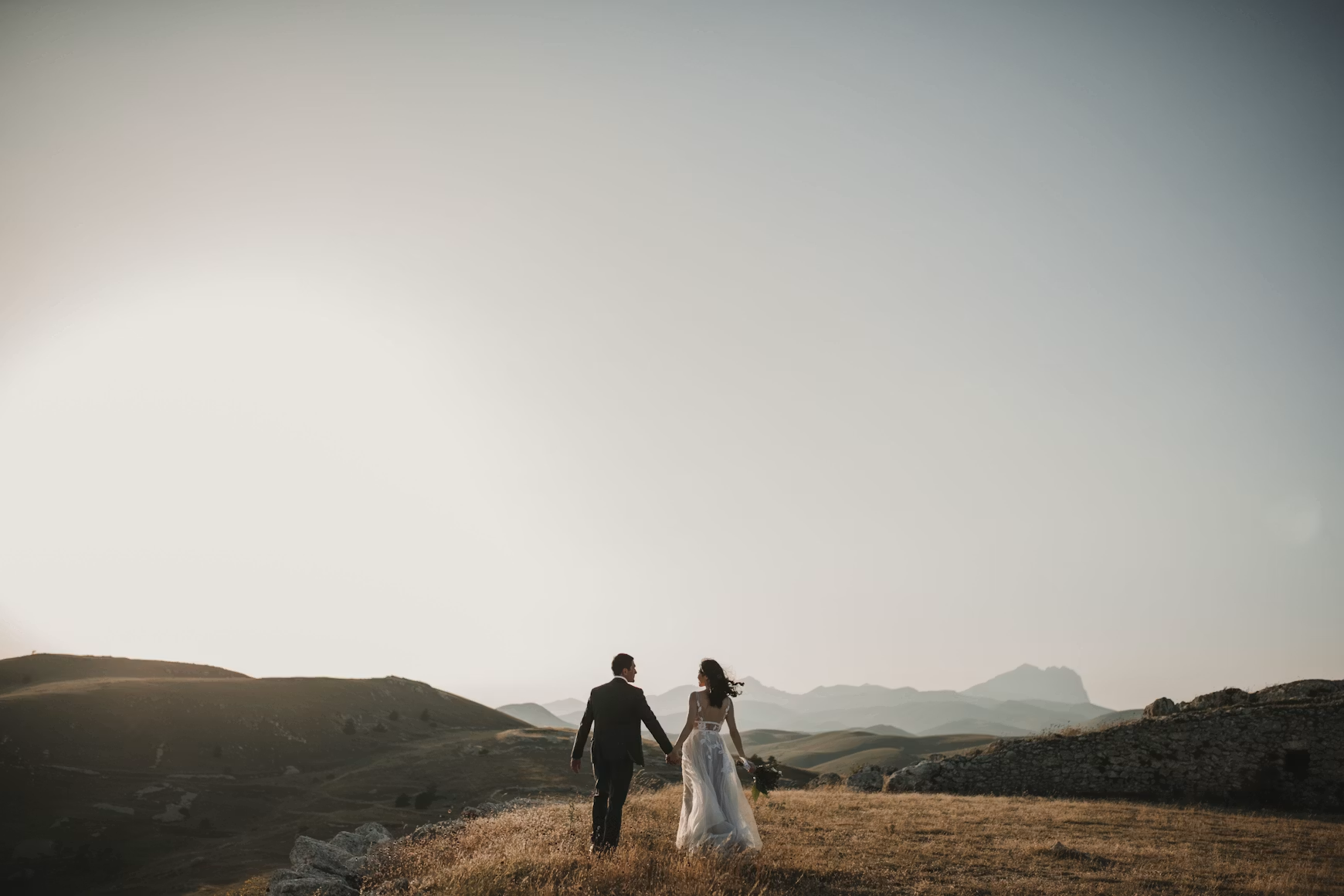 Couple embracing on a mountain ridge at golden hour